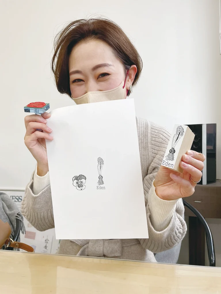 写真：ゴム印を紙に押して微笑む女性